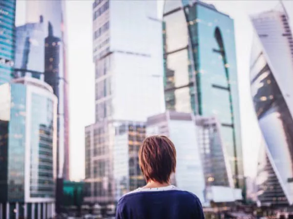 Woman standing near apartment buildings.