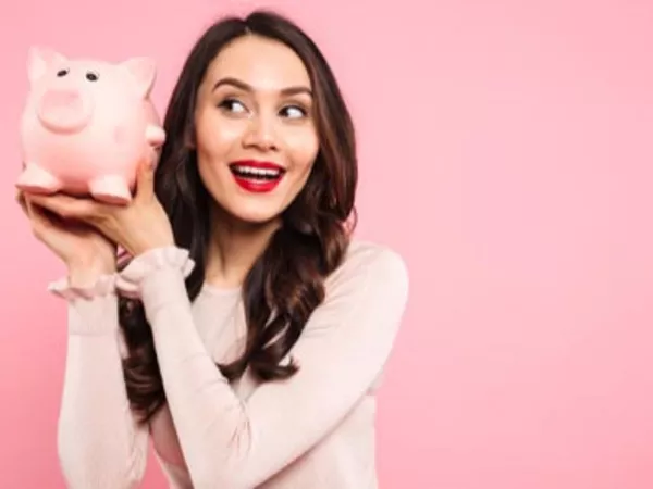 Woman holding a piggy bank, showing the savings she got using moving coupons.