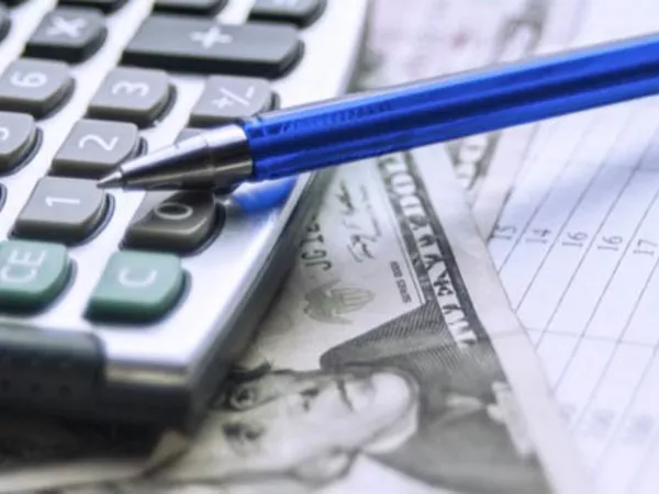 Stacks of coins beside a piggy bank to illustrate figuring out moving costs.