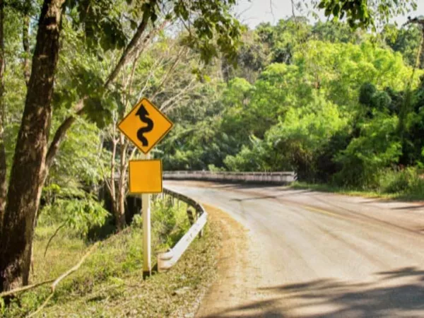 Curvy road and warning sign, showing a very dangerous road in the United States.