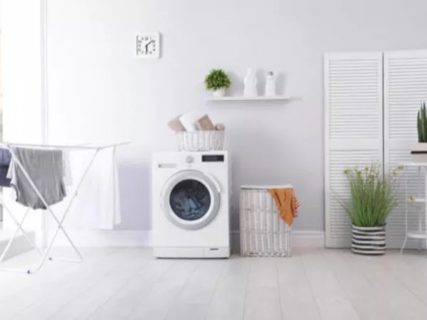 Washer and drying rack in a clean white laundry room.