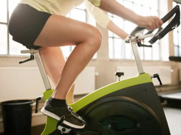 Person using a bike before cleaning and packing heavy gym equipment for a move.