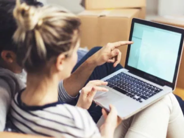 Couple figuring out how to pack a computer online.