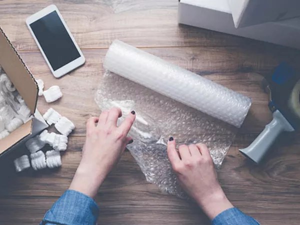 Person carefully packing collectible items.