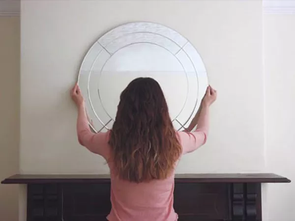 A woman using U-Pack packing tips to prepare picture frames for moving.