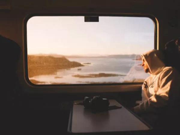 A man rests against a train window after saying goodbye to family and friends.