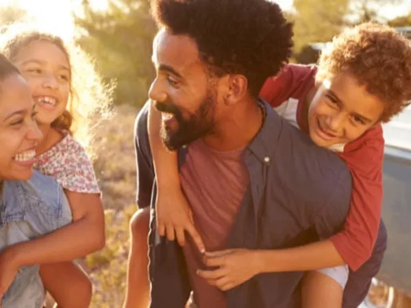 Family of four outside a rental truck, wondering if they can fit inside.