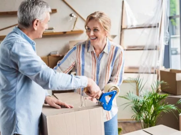 Couple packs moving boxes together while self-moving.