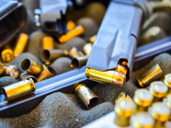 Image of firearms being unloaded and ammo sitting ready to be shipped.
