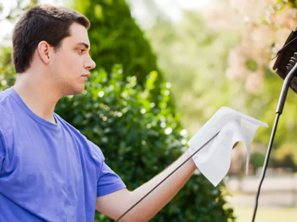 Man checks his oil as he goes through the pre-trip car maintenance checklist.