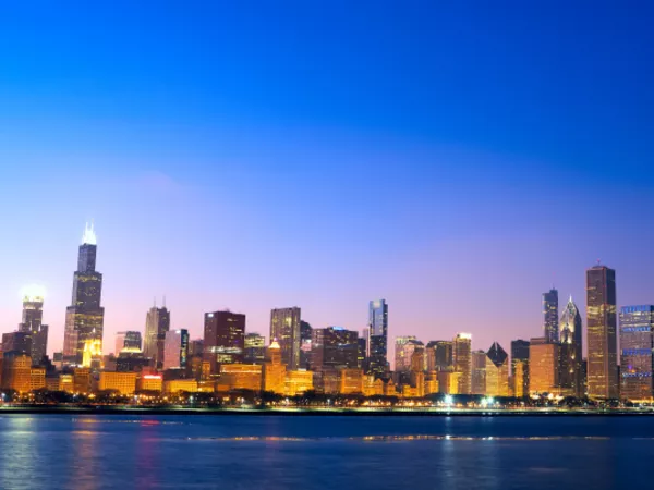 Image of Downtown Chicago, Illinois skyline across Lake Michigan at sunset.