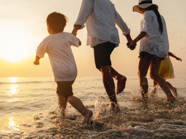 A family enjoys time on the beach to avoid snow.