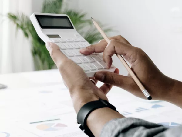 A person using a calculator to figure out how to finance a move.