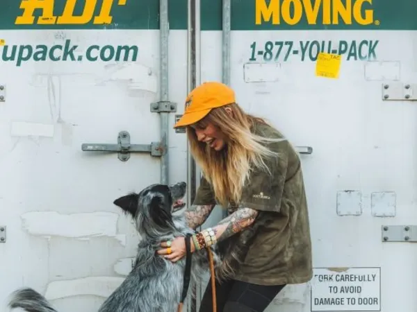 A woman with her dog in front of a U-Pack ReloCube after reviewing their transparent pricing.