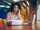 Woman calling on cell phone to find out if U-Haul will rent a trailer with a Ford Explorer.
