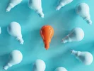 Image with white lightbulbs and an orange bulb in the midlde, showing the discovery of U-Haul discount codes.