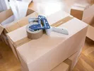 Cheap moving supplies like a tape dispenser sitting on top of a box.