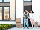 Couple standing outside their home before moving from Canada to the U.S.