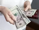 Woman counting money to pay movers, determining their tip.