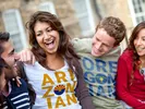 Group of people laughing while wearing shirts saying what people from Arizona and Oregon are called.
