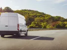 Small moving van driving on the road.