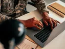 A person using a laptop to research ways to pay for a military move.